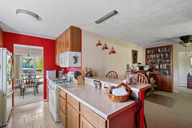 kitchen featuring ceiling fan, white appliances, pendant lighting, a textured ceiling, and light tile floors