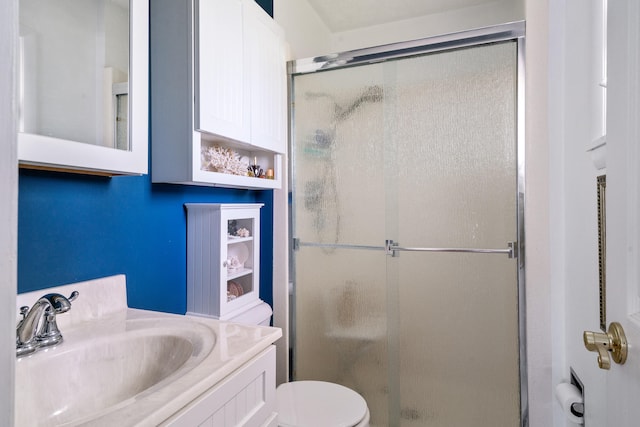 bathroom featuring an enclosed shower, vanity, and toilet