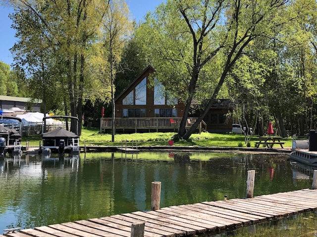 view of dock with a yard and a water view