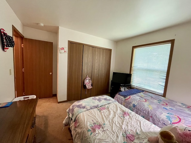 bedroom with light carpet and a closet