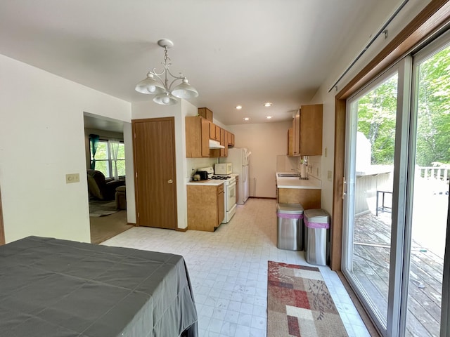 bedroom featuring white fridge, sink, access to outside, and an inviting chandelier