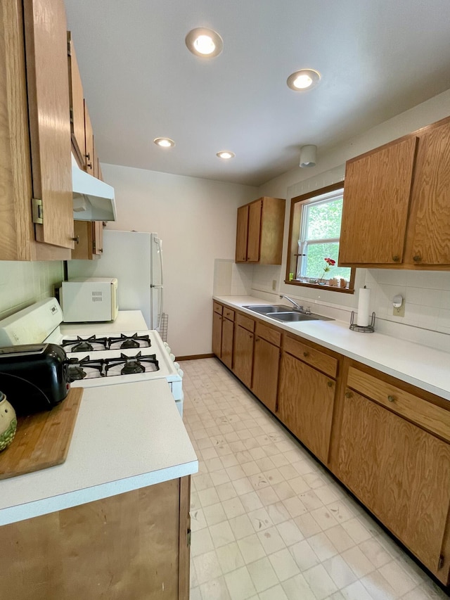 kitchen with tasteful backsplash, sink, and white appliances