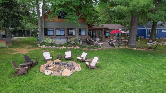 rear view of property featuring an outdoor fire pit, a patio area, and a lawn