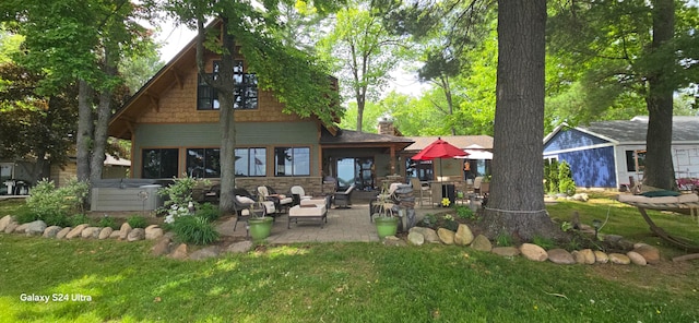 back of house featuring a patio area and a lawn