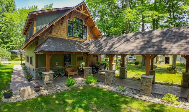 rear view of house featuring a patio, an outdoor living space, and a lawn