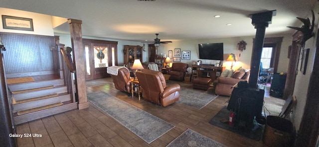 living room with a wealth of natural light, hardwood / wood-style floors, a wood stove, and ceiling fan