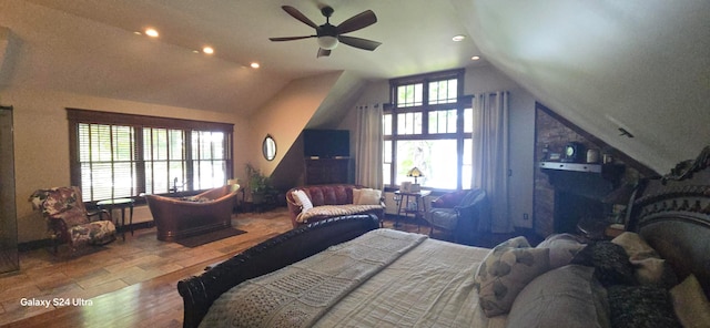 bedroom with ceiling fan, vaulted ceiling, and hardwood / wood-style floors