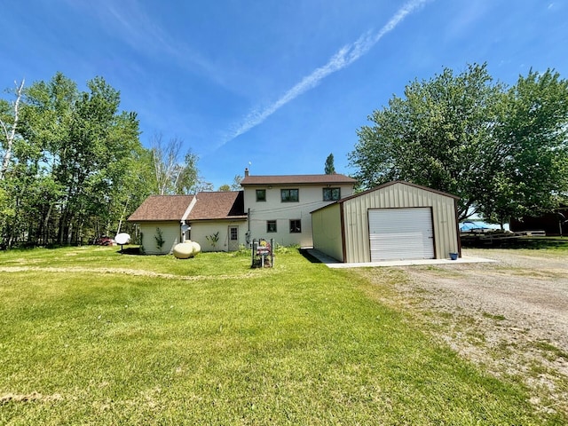 view of front of property with a front yard, an outbuilding, and a garage