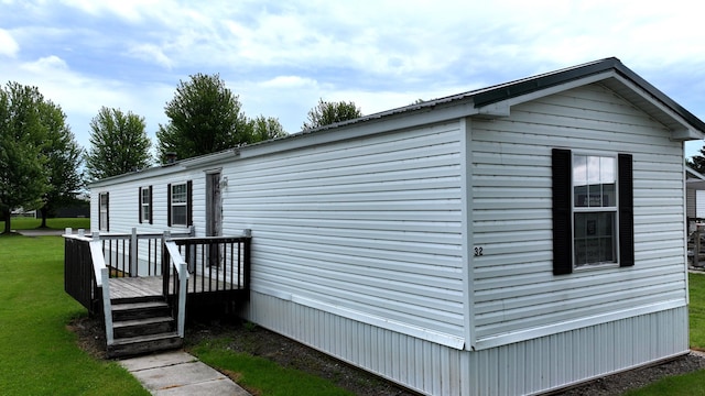 view of side of property with a lawn and a wooden deck