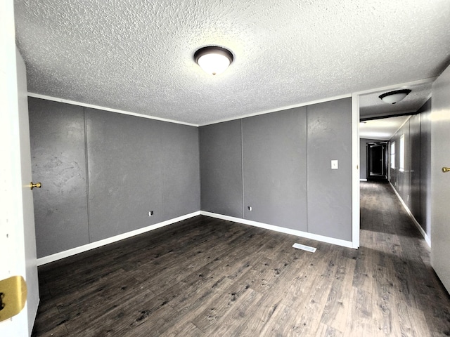 empty room featuring dark hardwood / wood-style flooring and ornamental molding