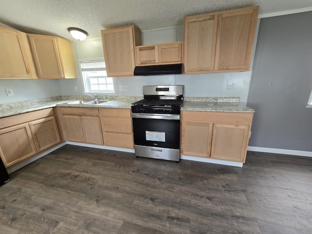 kitchen featuring stainless steel gas range oven, a textured ceiling, dark wood-type flooring, sink, and light brown cabinets