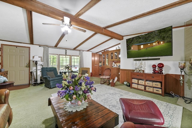 carpeted living room with lofted ceiling with beams, ceiling fan, a textured ceiling, and wooden walls