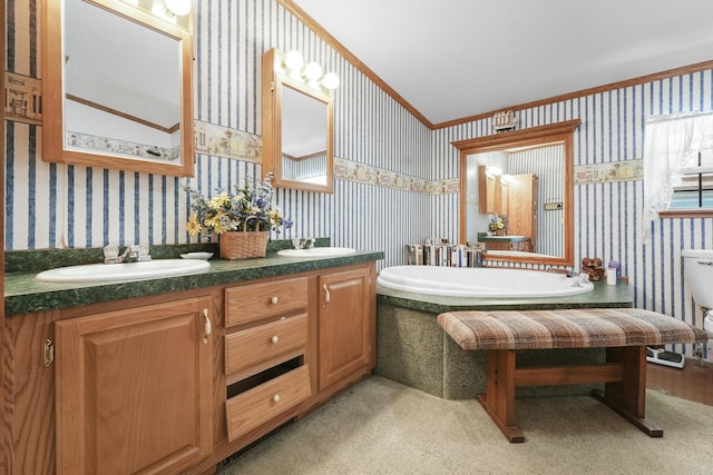 bathroom with a bathing tub, vanity, ornamental molding, and vaulted ceiling