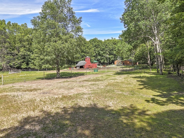 view of yard with an outbuilding and a rural view