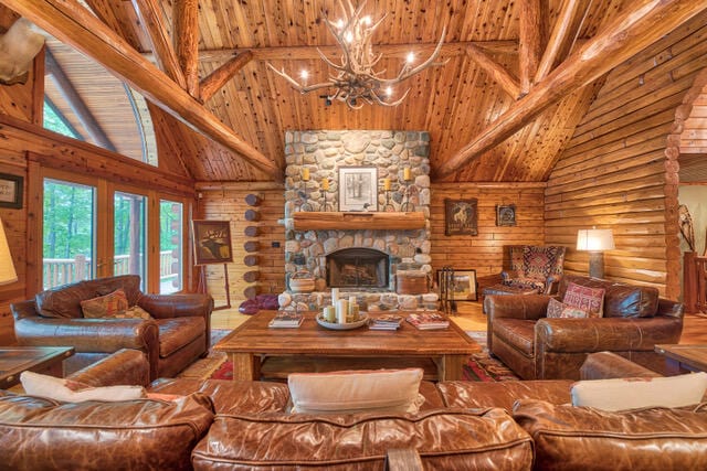 living room featuring a stone fireplace, beam ceiling, rustic walls, high vaulted ceiling, and wooden ceiling