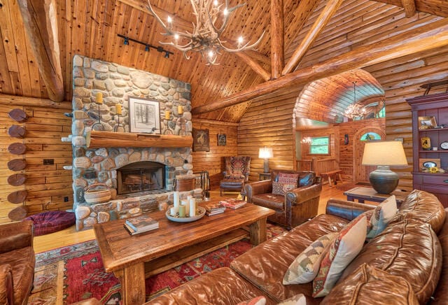 living room featuring a stone fireplace, high vaulted ceiling, beam ceiling, and rustic walls