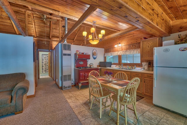 kitchen with decorative light fixtures, white fridge, wood ceiling, and light tile floors