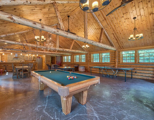 recreation room featuring concrete flooring, wood ceiling, billiards, high vaulted ceiling, and a chandelier