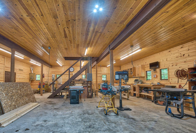 interior space with wooden walls, a workshop area, and wooden ceiling