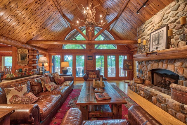 living room featuring high vaulted ceiling, beamed ceiling, rustic walls, and a fireplace