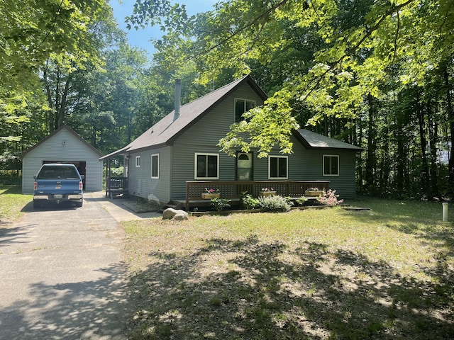 view of front of home with a garage, a front yard, an outbuilding, and a deck