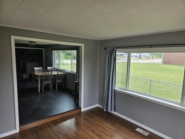 unfurnished room featuring plenty of natural light and dark hardwood / wood-style floors