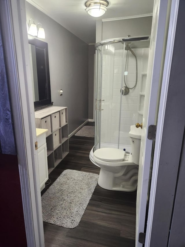 bathroom with a shower with shower door, vanity, toilet, and hardwood / wood-style flooring