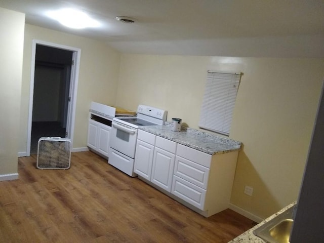 kitchen with white range with electric cooktop, hardwood / wood-style flooring, white cabinetry, and vaulted ceiling