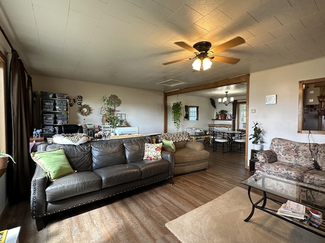 living room featuring ceiling fan with notable chandelier and wood-type flooring