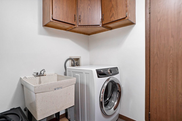 washroom with sink, cabinets, and washer / dryer