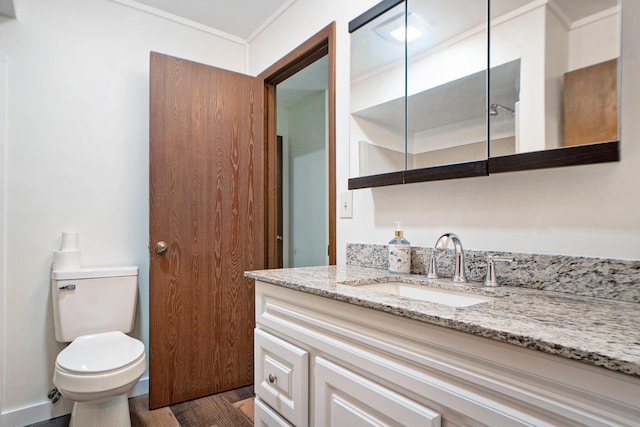 bathroom featuring vanity, toilet, wood-type flooring, and crown molding