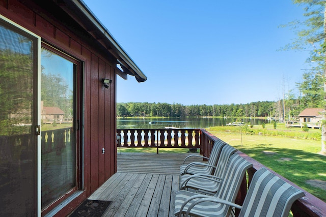 deck with a water view and a lawn