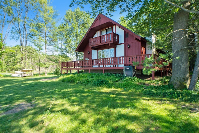 back of house featuring central AC unit, a lawn, and a deck