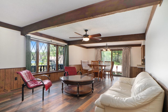 living room with beam ceiling, a textured ceiling, dark hardwood / wood-style flooring, and ceiling fan