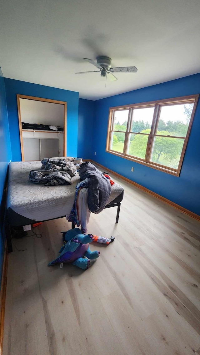 bedroom featuring ceiling fan, hardwood / wood-style floors, and a closet