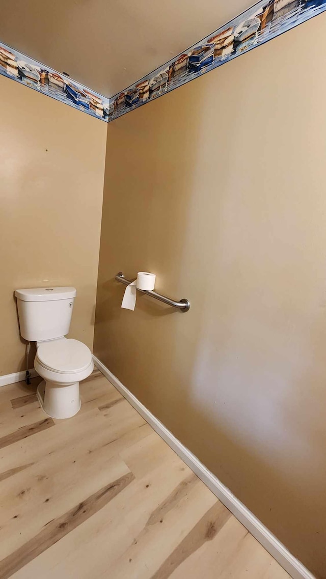 bathroom with toilet and hardwood / wood-style floors