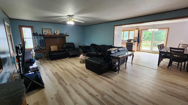 living room featuring ceiling fan with notable chandelier and hardwood / wood-style flooring