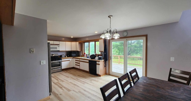 kitchen with black dishwasher, stainless steel range, light hardwood / wood-style floors, decorative light fixtures, and a notable chandelier