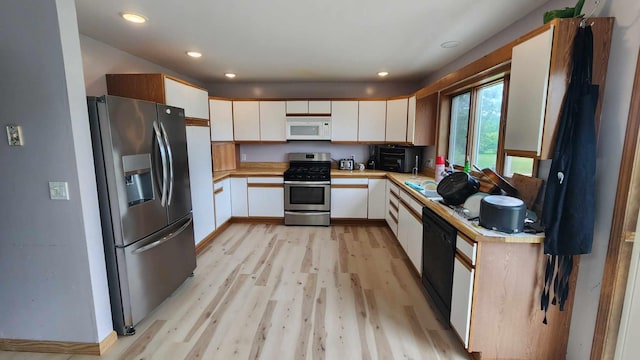 kitchen with appliances with stainless steel finishes, light wood-type flooring, and white cabinetry