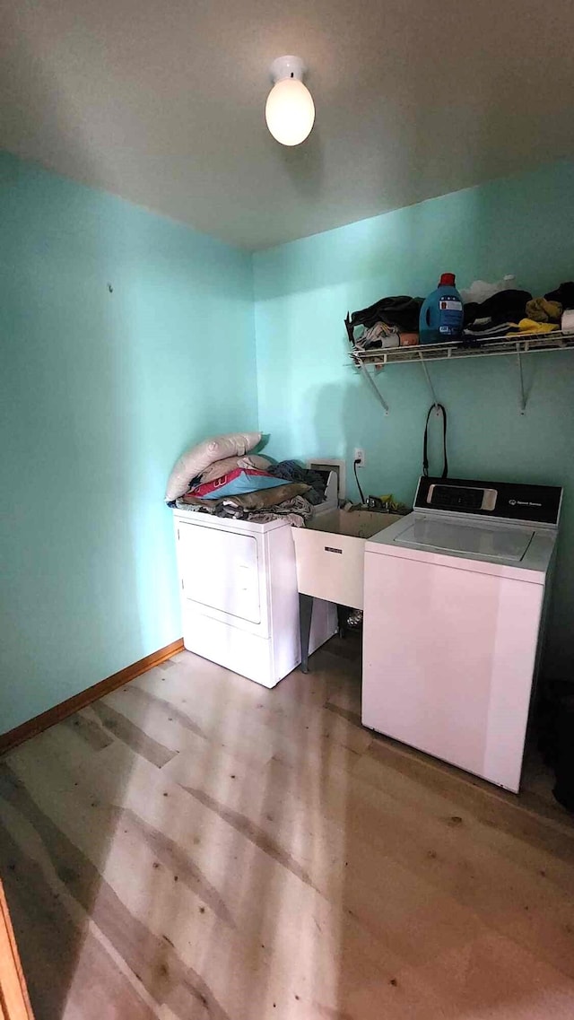 clothes washing area featuring hardwood / wood-style floors and washing machine and clothes dryer