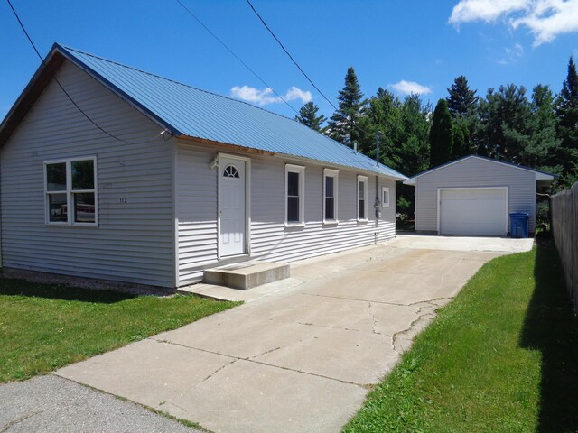 view of front of house with an outbuilding, a garage, and a front lawn