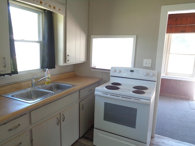 kitchen featuring white cabinetry, sink, light carpet, and white electric stove