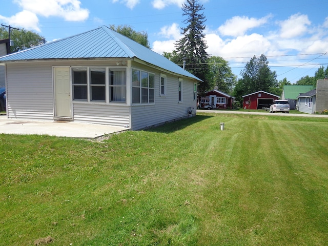 view of side of home with a yard and a patio