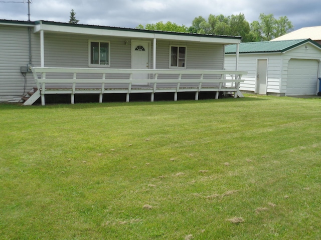 back of house featuring a lawn and an outdoor structure