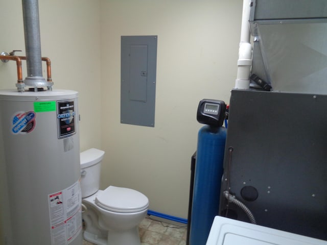 bathroom featuring electric panel, water heater, and toilet