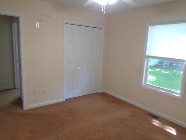 unfurnished bedroom with carpet, ceiling fan, and a closet