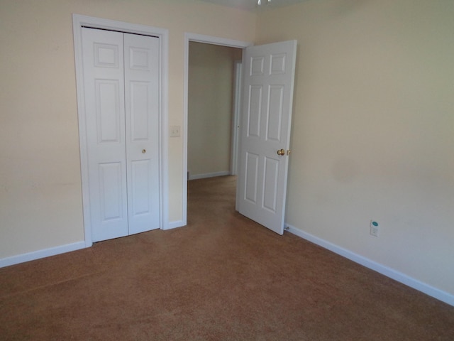 unfurnished bedroom featuring carpet flooring and a closet