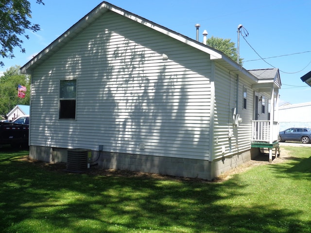 view of home's exterior featuring a lawn and central AC