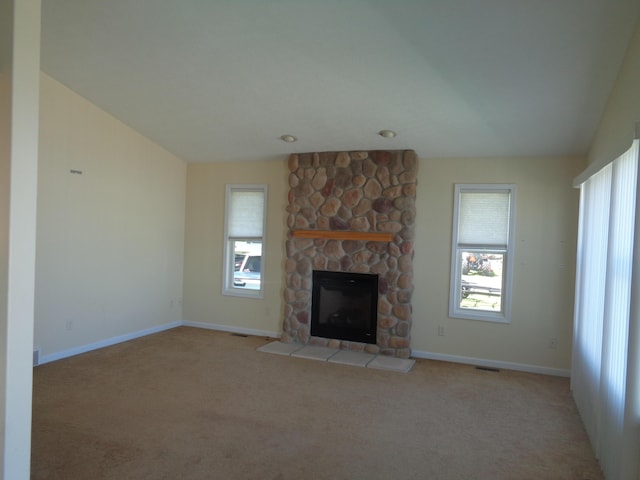 unfurnished living room featuring light carpet, a stone fireplace, and lofted ceiling