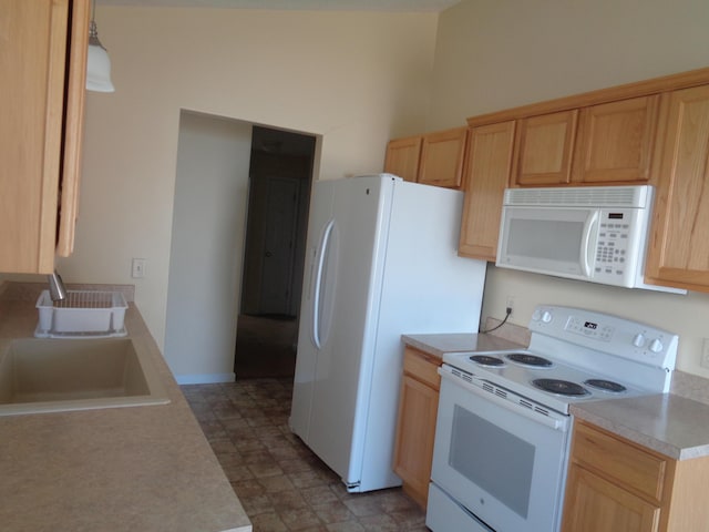 kitchen with light brown cabinets, white appliances, and sink